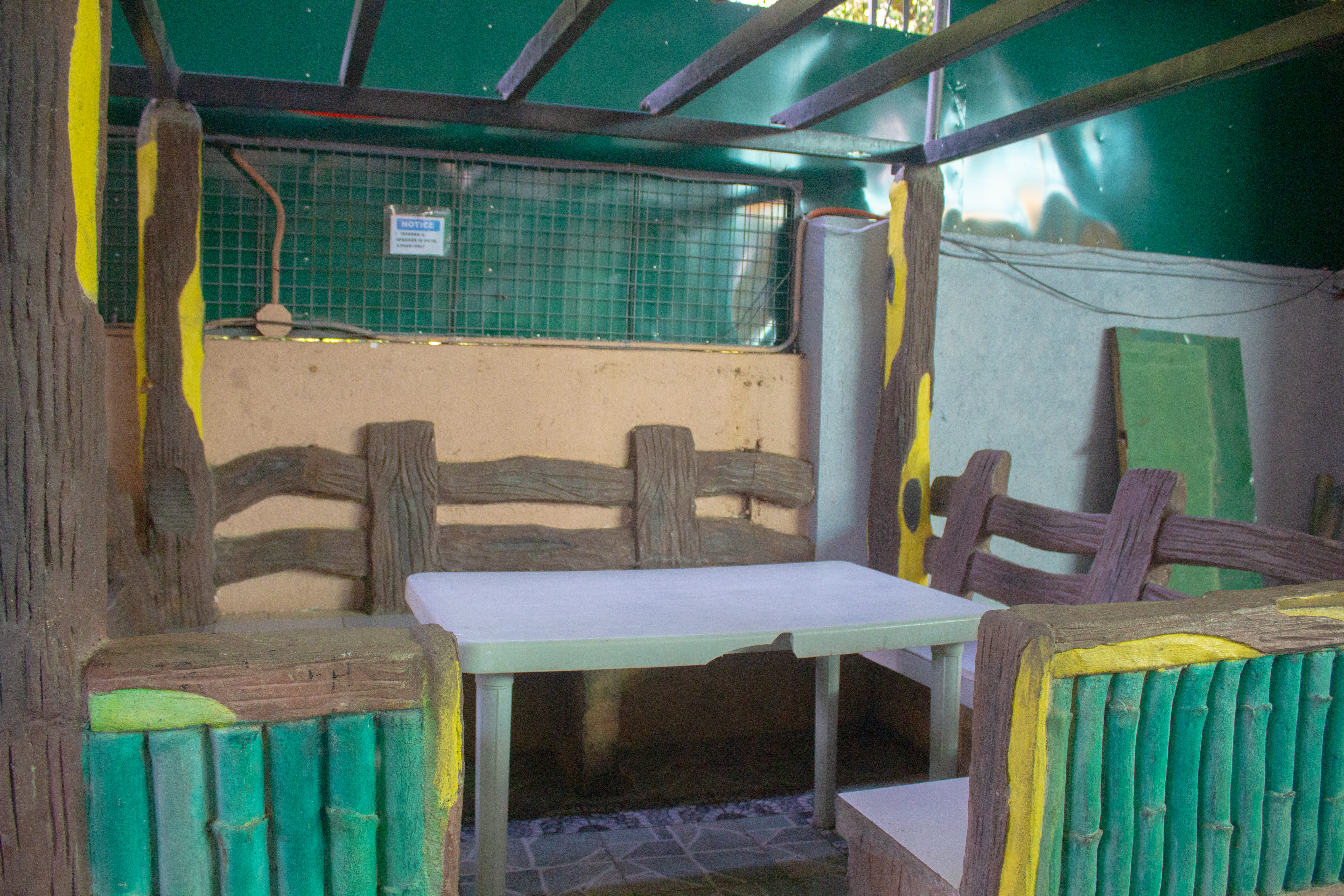 A shaded seating area with a combination of bamboo and wooden elements, creating a nature-themed ambiance.